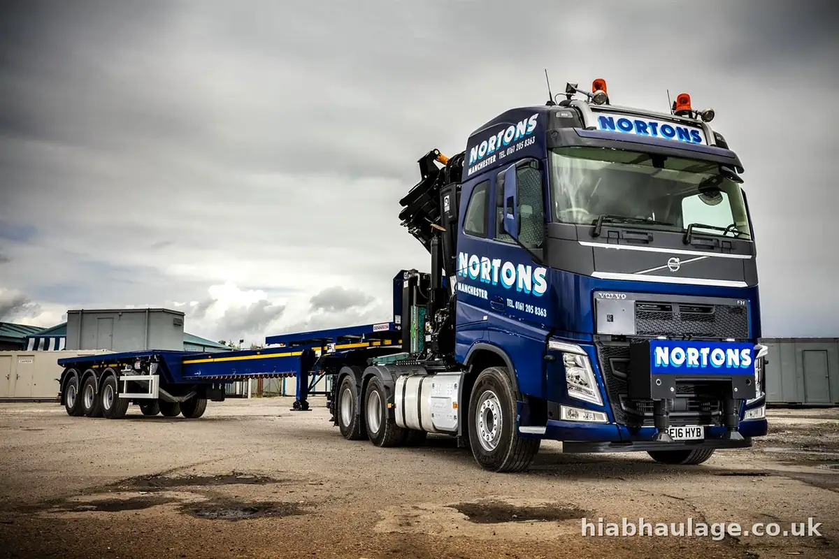Artic HIAB tractor unit coupled to an empty flat trailer in the yard Artic HIAB tractor unit coupled to an empty flat trailer in the yard