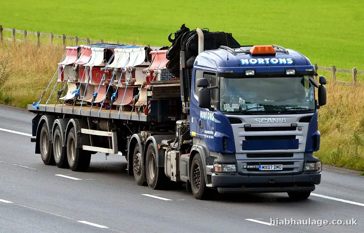 Scania HIAB and trailer carrying red machinery parts on the M6