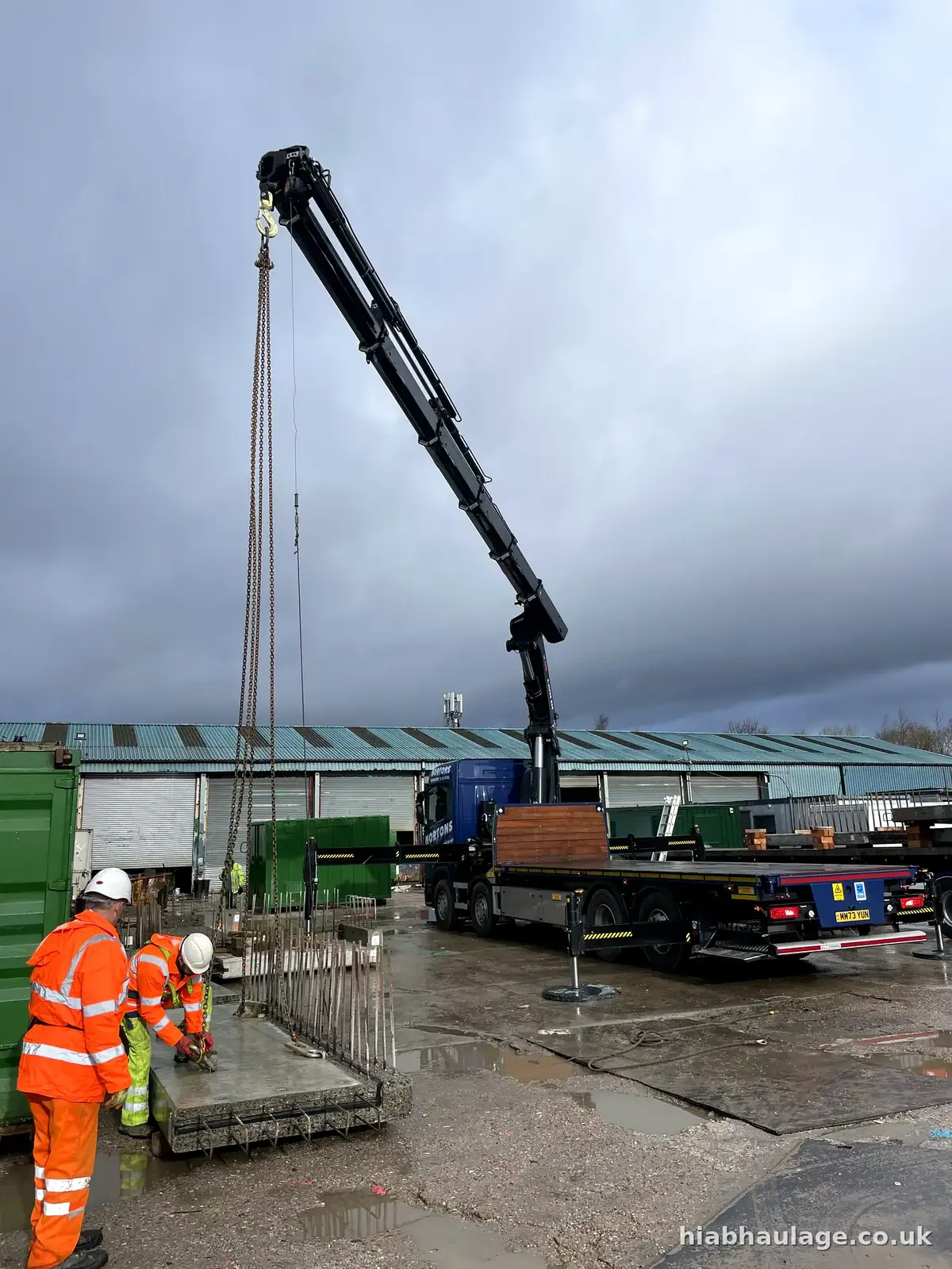 Crew guiding a precast concrete panel during a lift Crew guiding a precast concrete panel during a lift