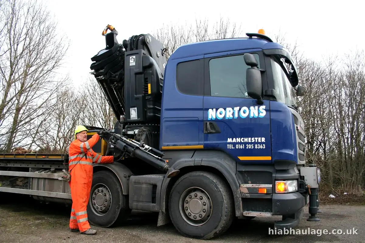 Driver at the controls on the side of a rigid HIAB lorry Driver at the controls on the side of a rigid HIAB lorry