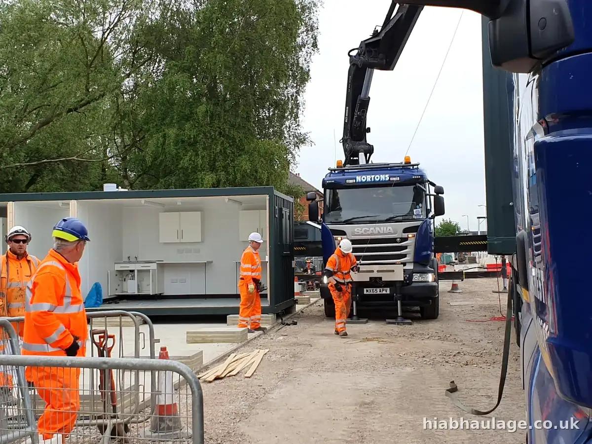 Crew beside a modular unit and Scania HIAB on a site Crew beside a modular unit and Scania HIAB on a site