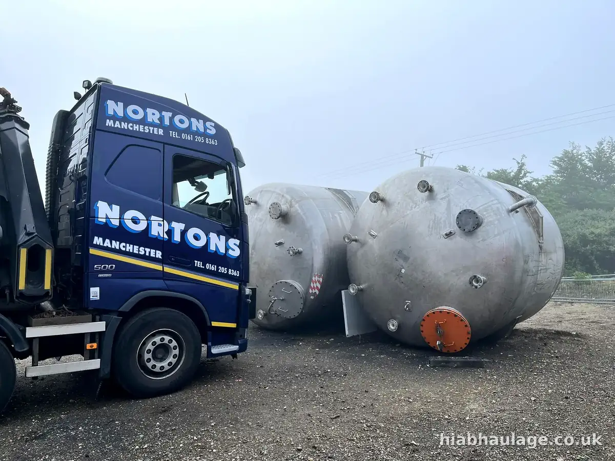 Volvo HIAB beside stainless steel storage tanks