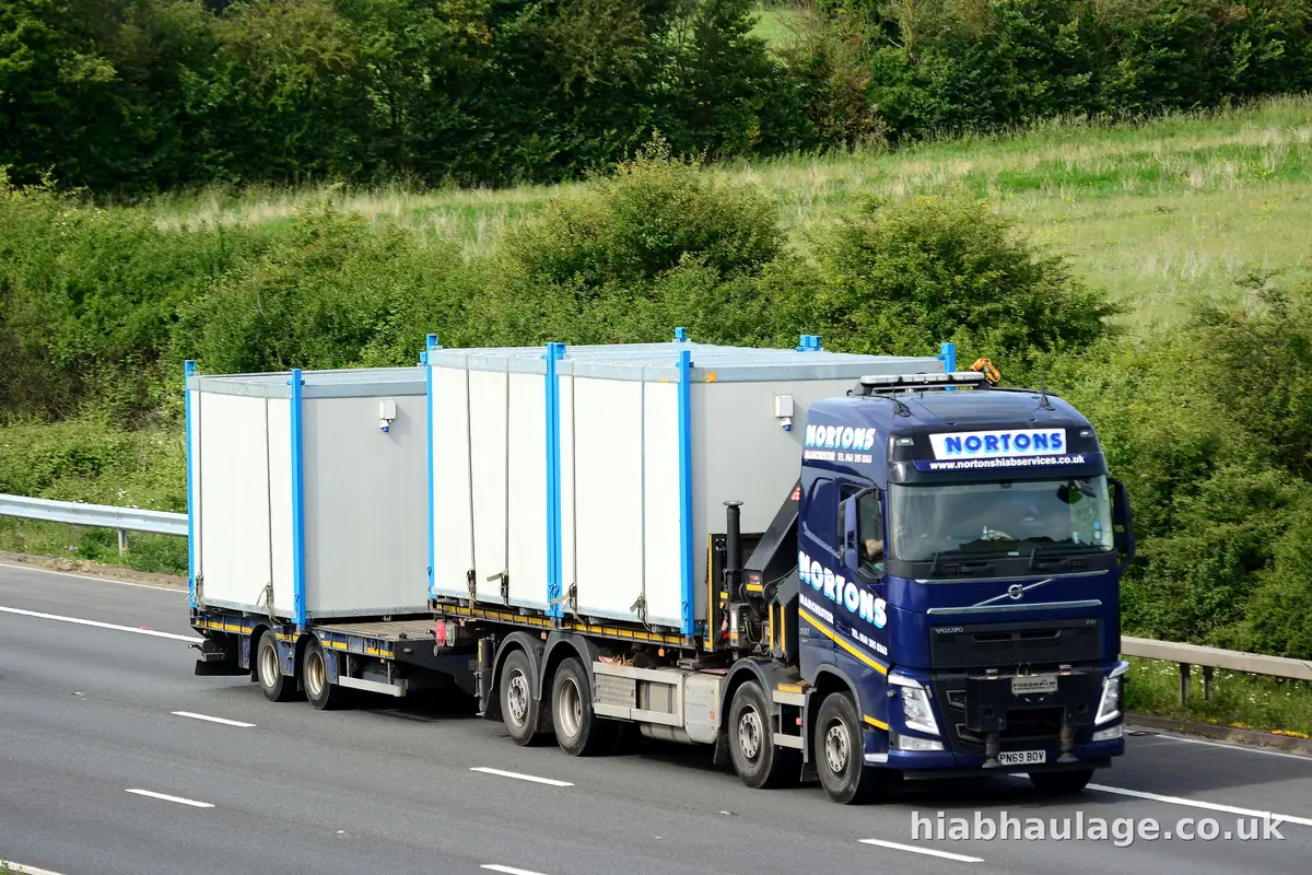 Wagon and drag HIAB carrying site units on the lorry and trailer along the motorway