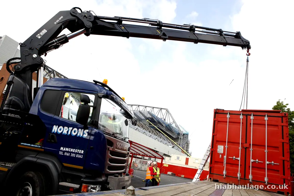 Scania HIAB lifting a red container beside a stadium Scania HIAB lifting a red container beside a stadium
