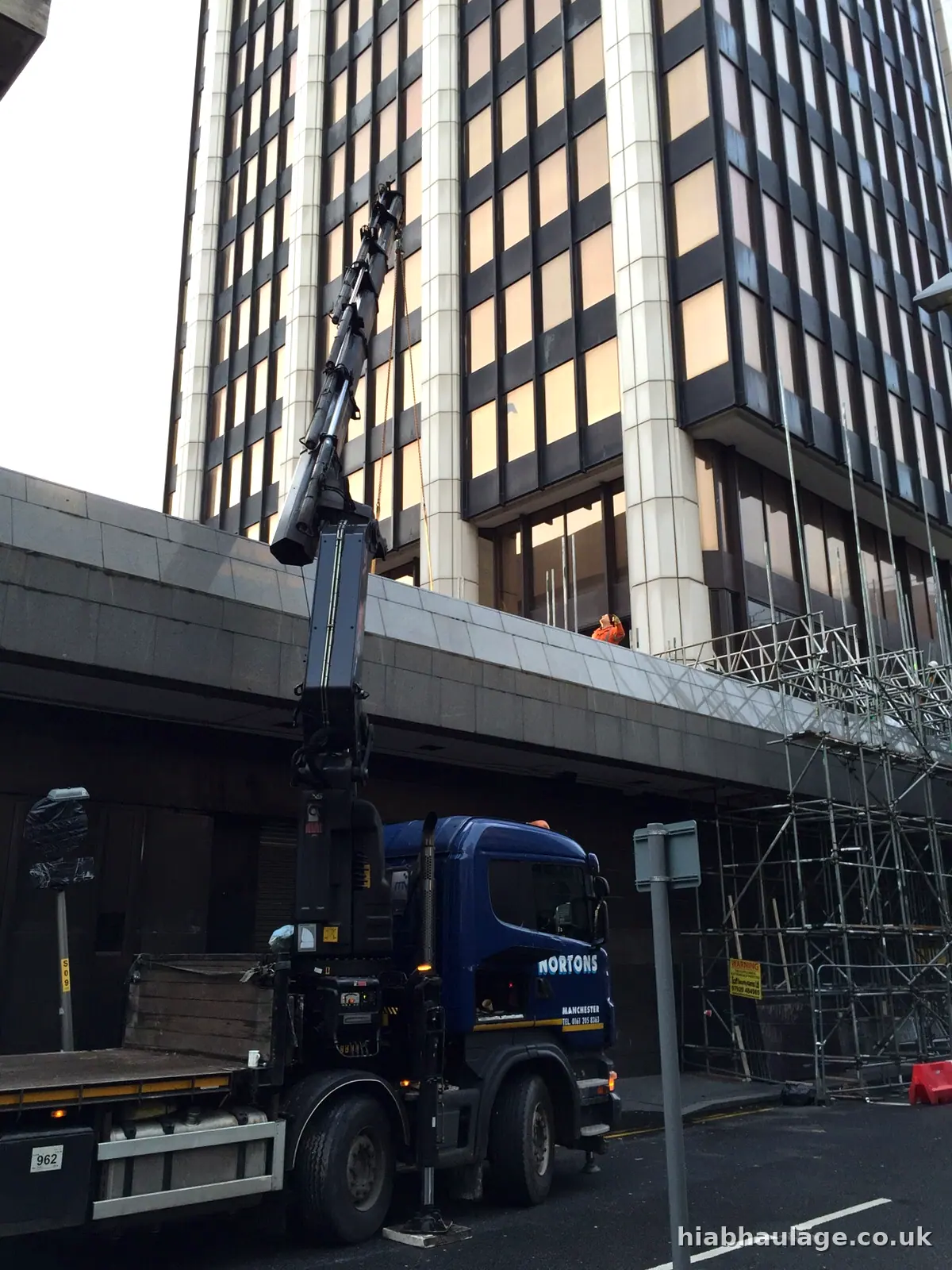 HIAB lorry parked beside an office tower in a city street