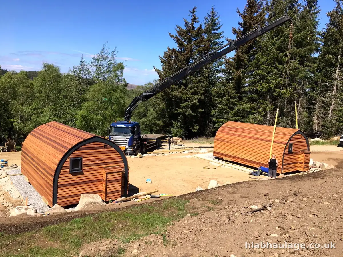 HIAB placing a pod on its base among pine trees HIAB placing a pod on its base among pine trees