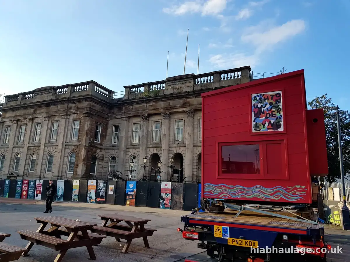 Red art pod on a HIAB flatbed outside a civic building