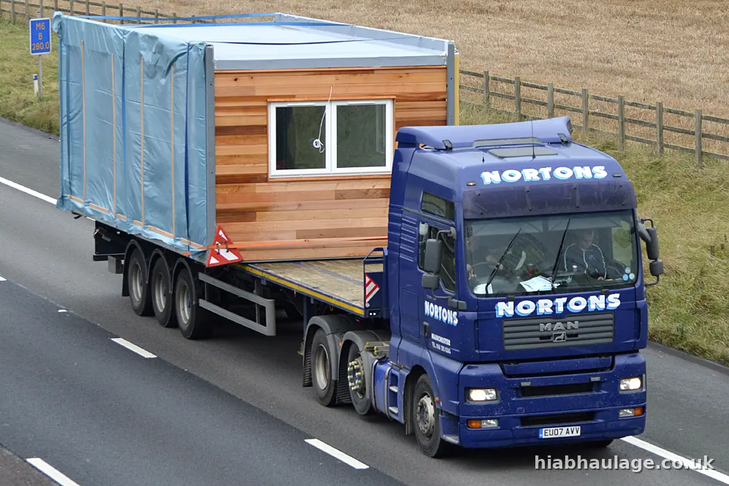 MAN artic carrying a timber clad unit on the motorway MAN artic carrying a timber clad unit on the motorway