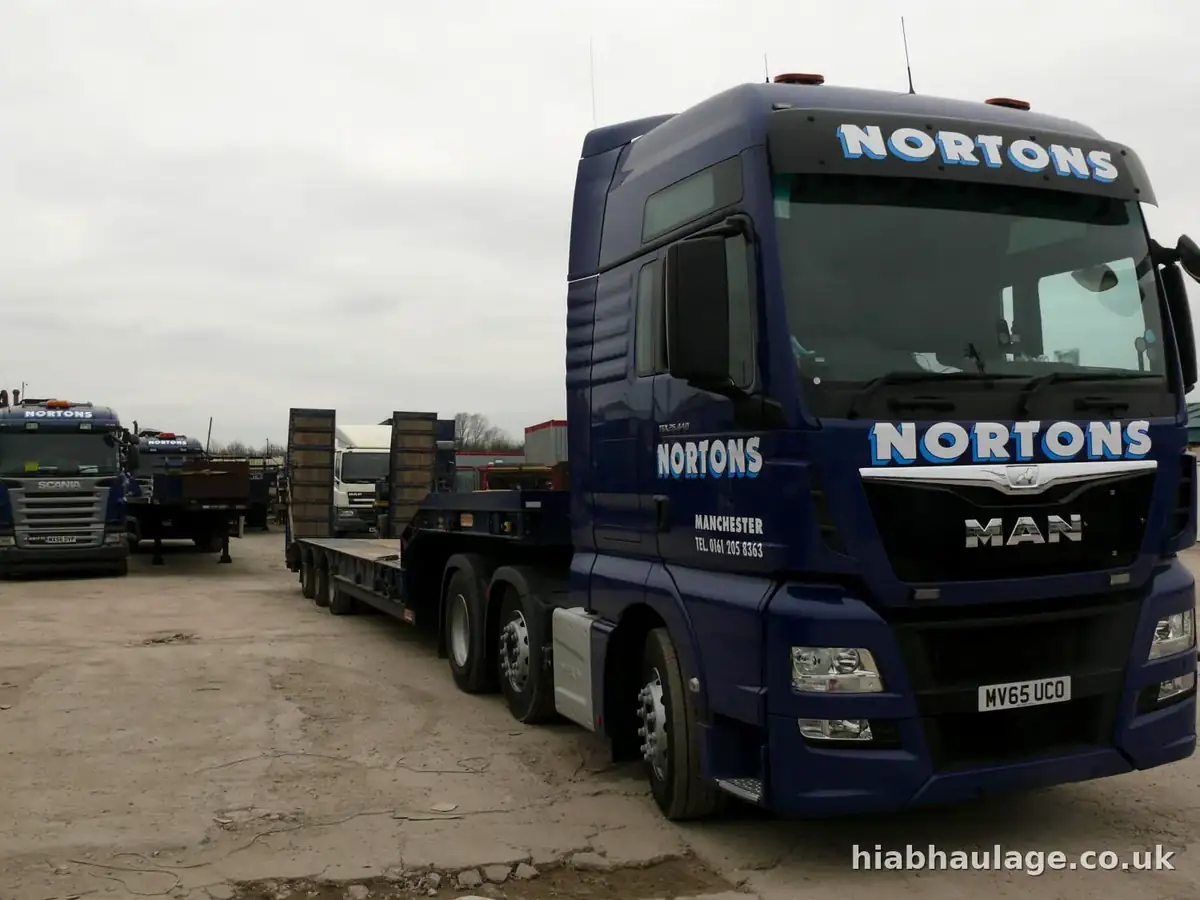MAN tractor unit coupled to a low loader trailer in the yard MAN tractor unit coupled to a low loader trailer in the yard