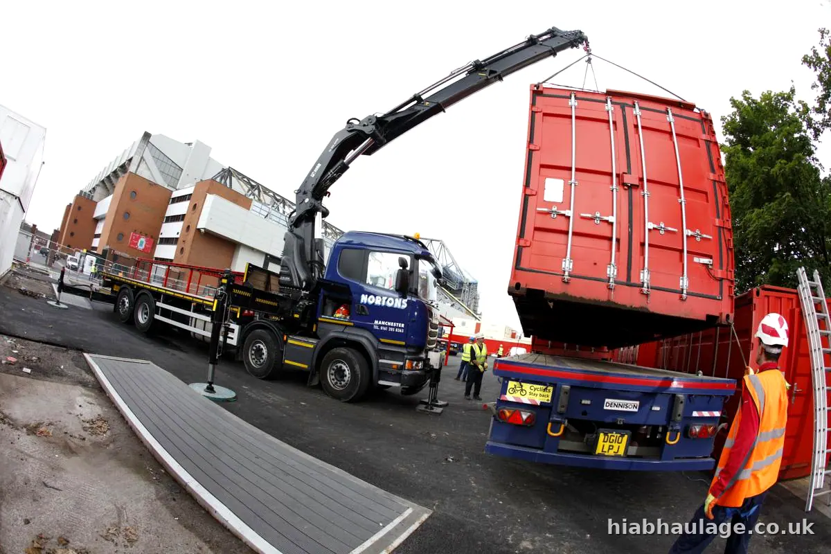 Red container lifted off a trailer with the slinger guiding it Red container lifted off a trailer with the slinger guiding it