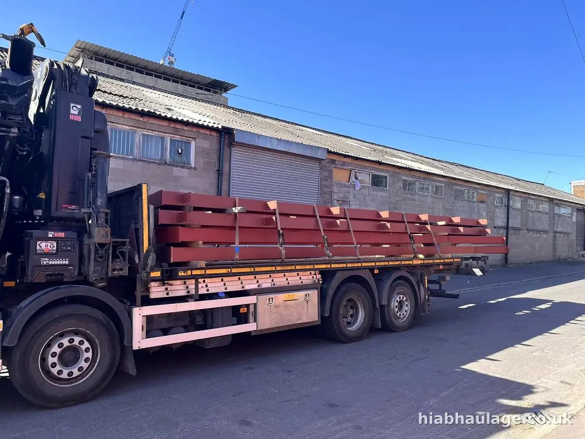 Red steel beams strapped to a rigid HIAB Red steel beams strapped to a rigid HIAB