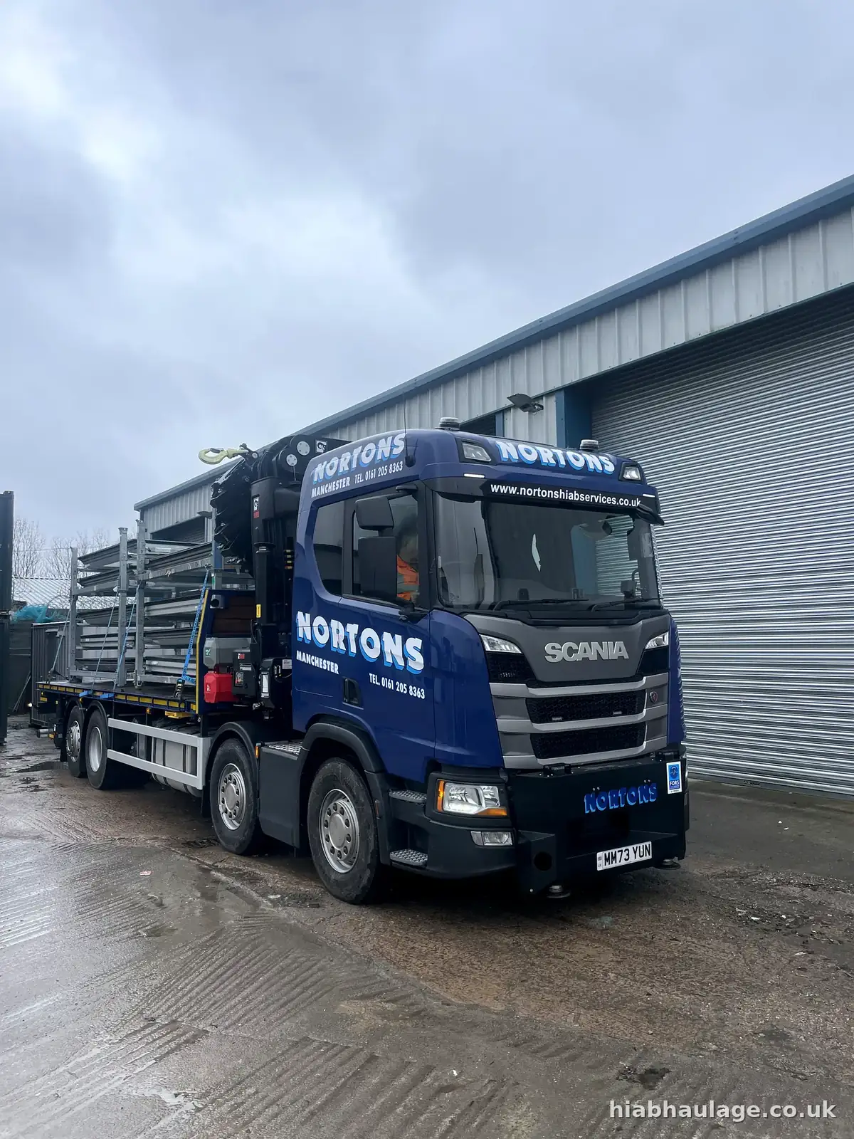 Rigid HIAB loaded with steel stillages outside an industrial unit Rigid HIAB loaded with steel stillages outside an industrial unit