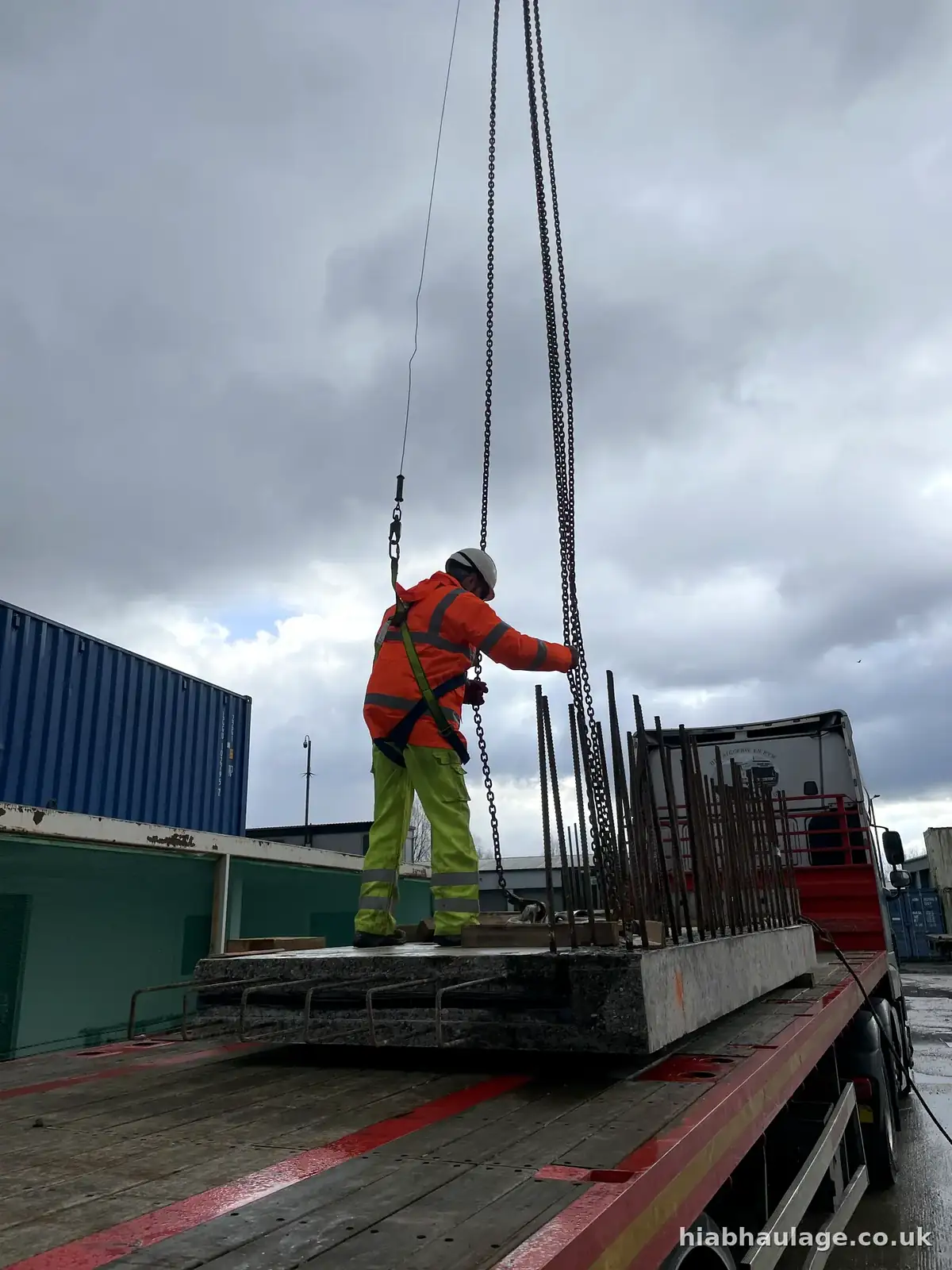 Slinger standing on a load attaching lifting gear Slinger standing on a load attaching lifting gear