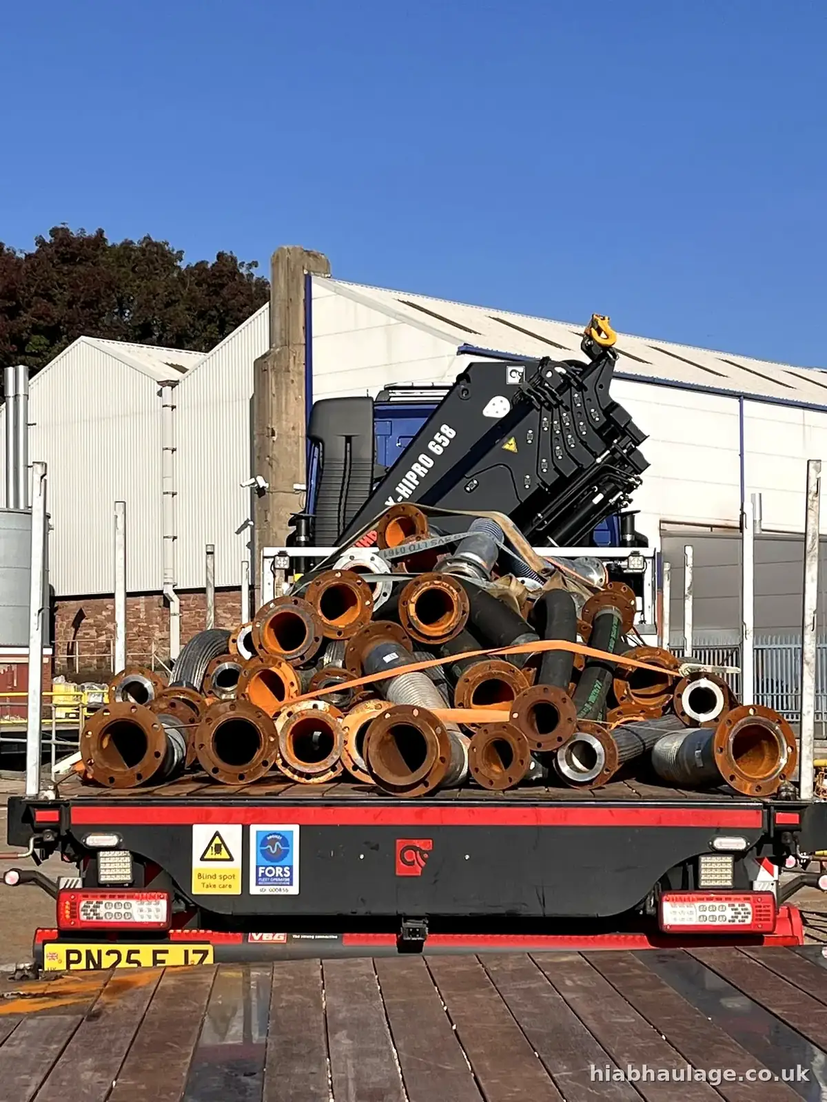 Steel pipe sections strapped on the rear of a flatbed Steel pipe sections strapped on the rear of a flatbed