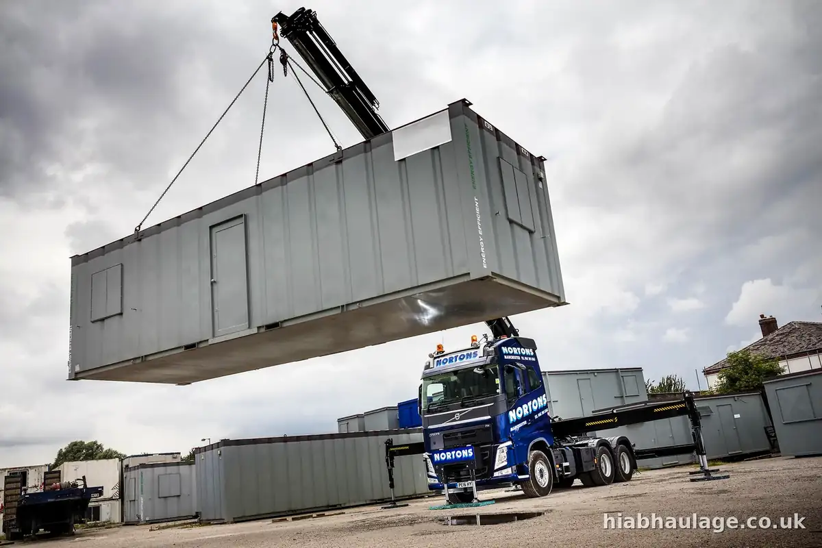 Steel site cabin lifted high over the yard by an artic HIAB Steel site cabin lifted high over the yard by an artic HIAB