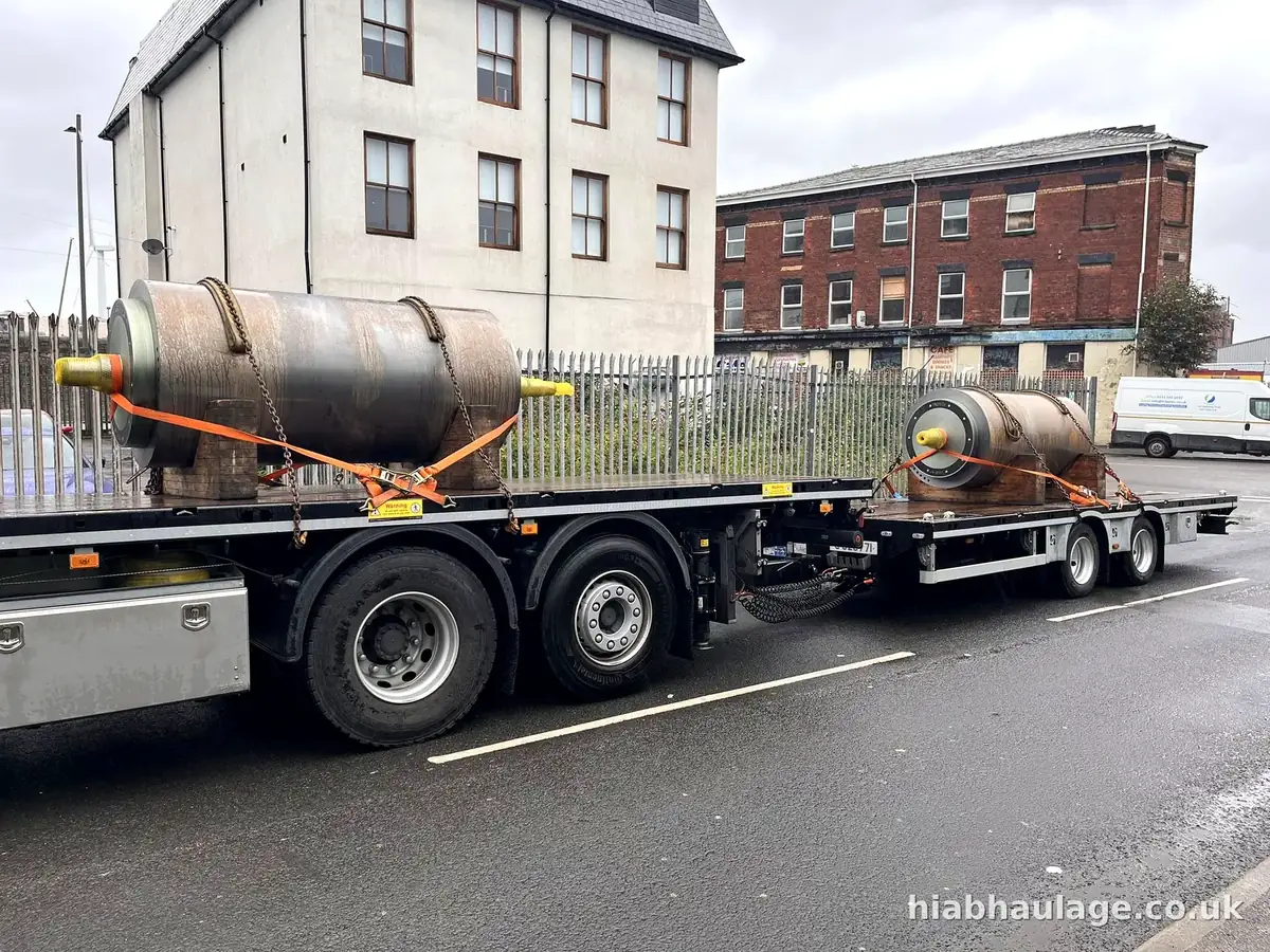 Two steel pressure vessels strapped to a rigid lorry and trailer in a town street Two steel pressure vessels strapped to a rigid lorry and trailer in a town street