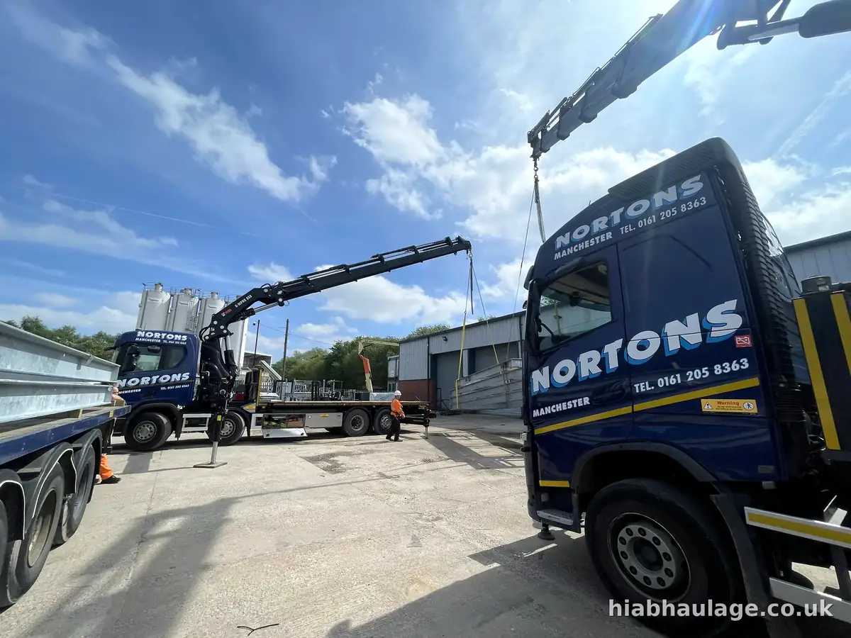 Two HIABs lifting steel frames, low angle