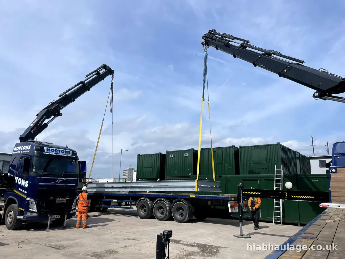 Two HIAB lorries working together to lift steel frames from a trailer Two HIAB lorries working together to lift steel frames from a trailer