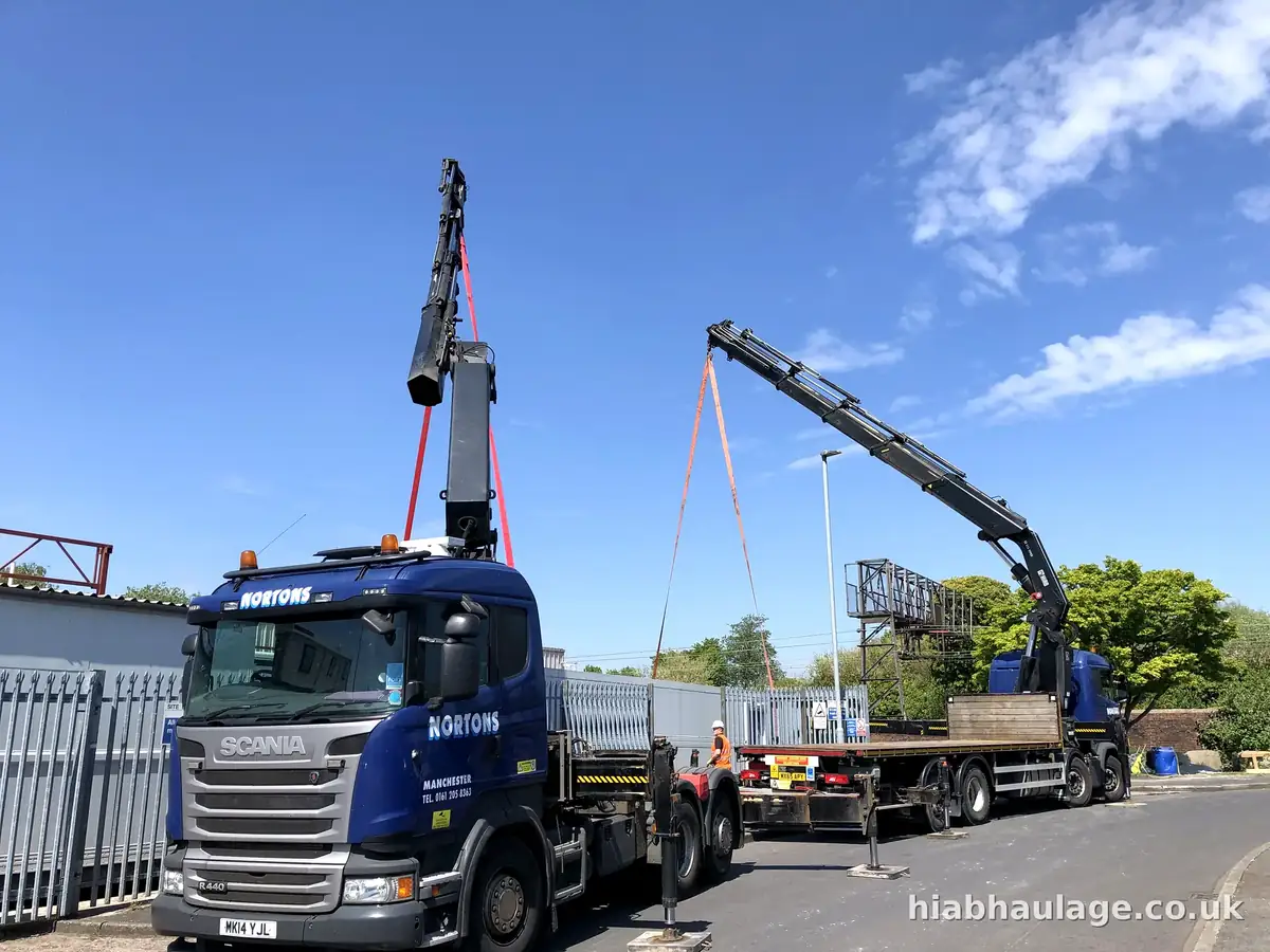 Two rigid HIABs set up together to lift a steel frame