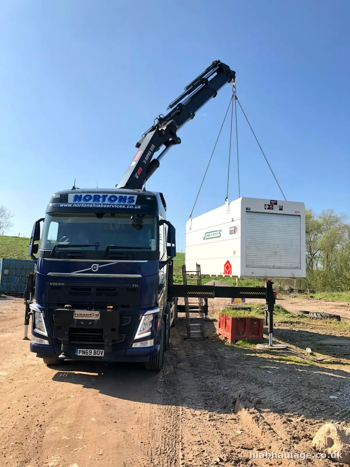 Volvo HIAB lifting a white unit on a site Volvo HIAB lifting a white unit on a site