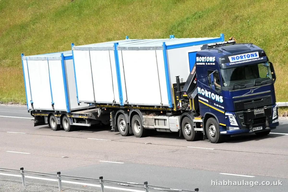 Wagon and drag carrying cabins along an English road Wagon and drag carrying cabins along an English road