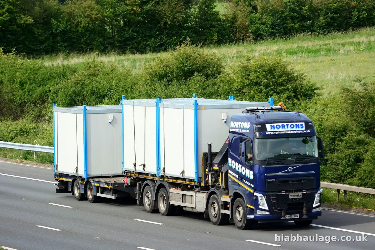 Wagon and drag carrying cabins along the road